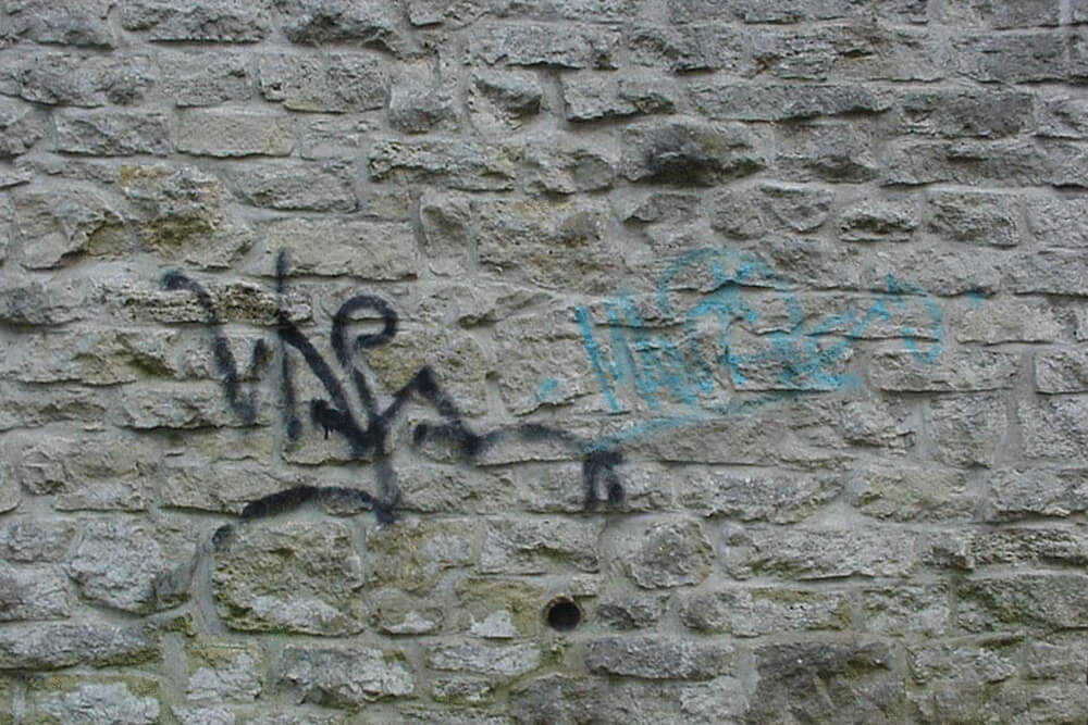Graffitientfernung - Natursteinwand vor der Reinigung